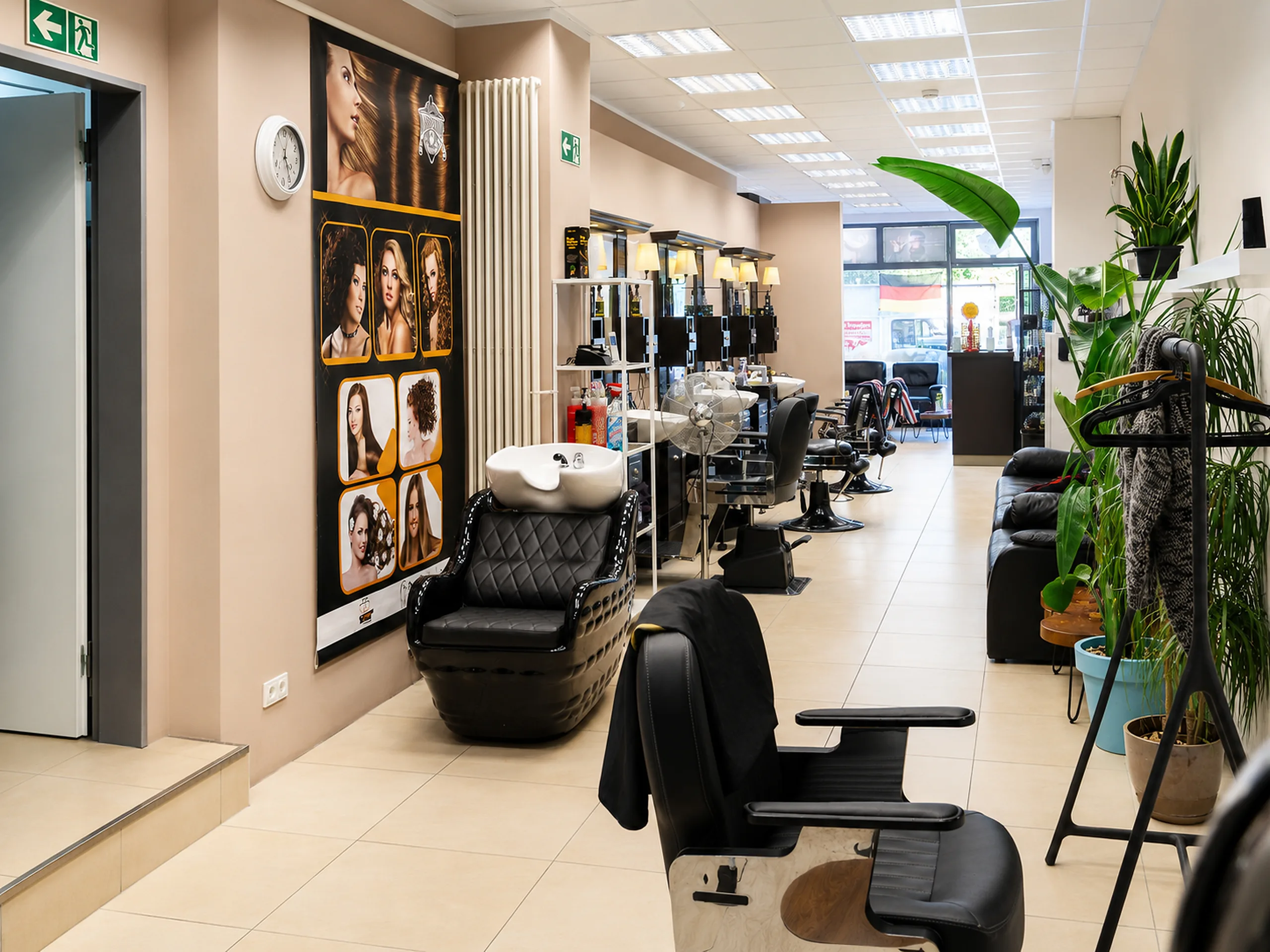 Innenraum vom Barbershop Kupferdreh in Essen mit Friseurstühlen, warmer Beleuchtung und Pflanzen